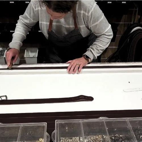 Person polishing leather belt in a workshop setting
